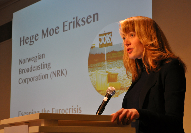 A woman talking from a podium. Behind her is a slide with the text "Hege Moe Eriksen"