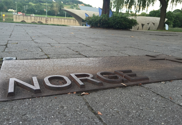 A plaque spelling out the word "Norge" on the ground.