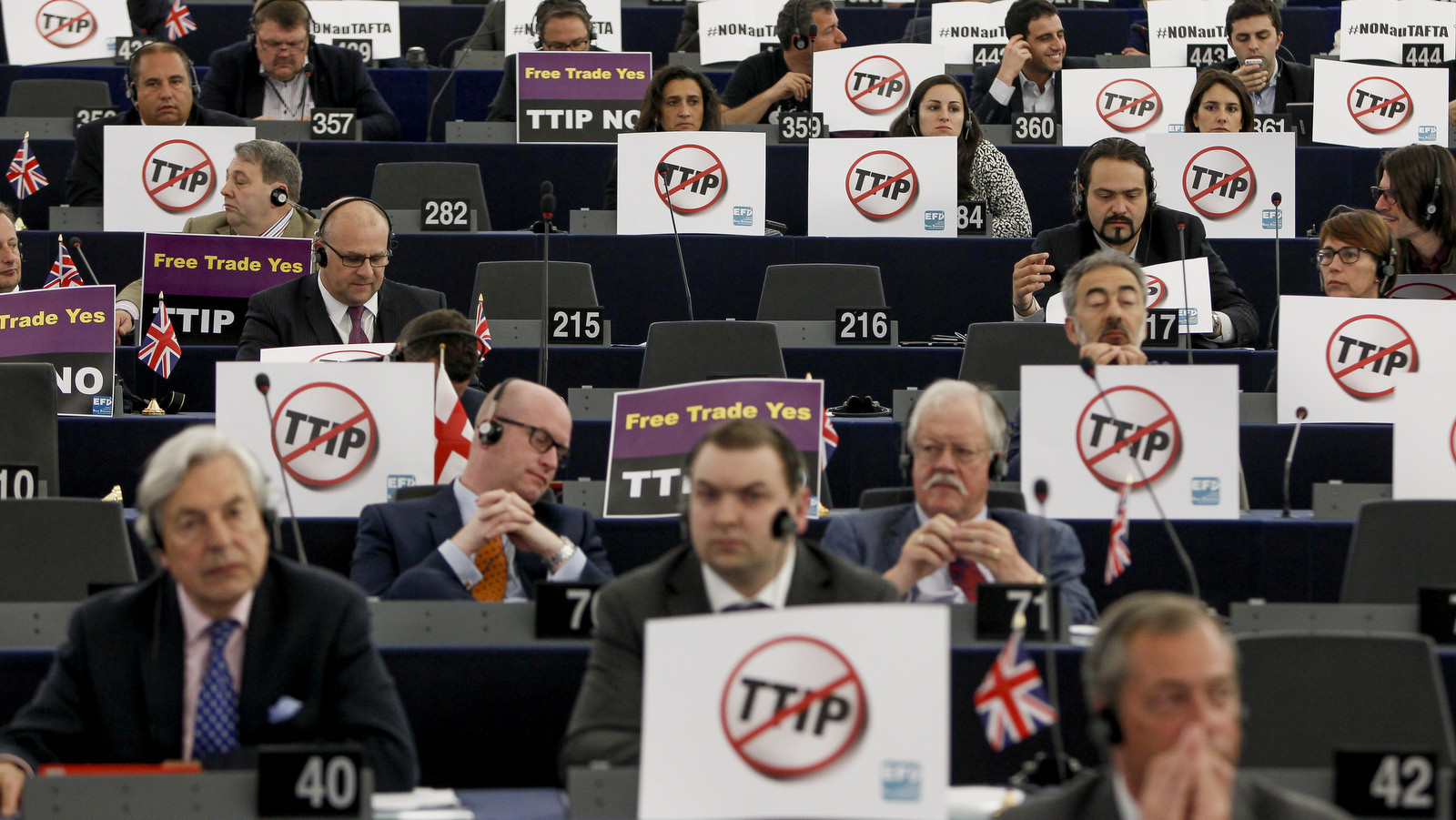 Seats with EU Parliament members with anti-TTIP signs 