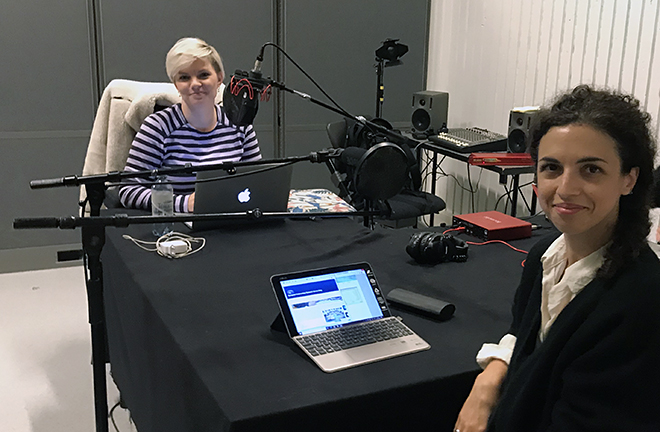 Two women sitting in a podcast studio.