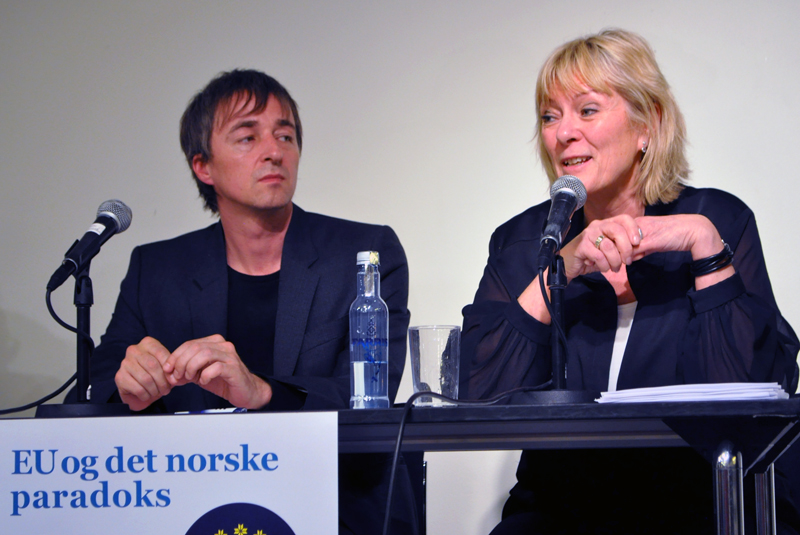 To personer (Sten Inge Jørgensen og Kristin Clemet) sitter ved et panel og foran hver sin mikrofon.