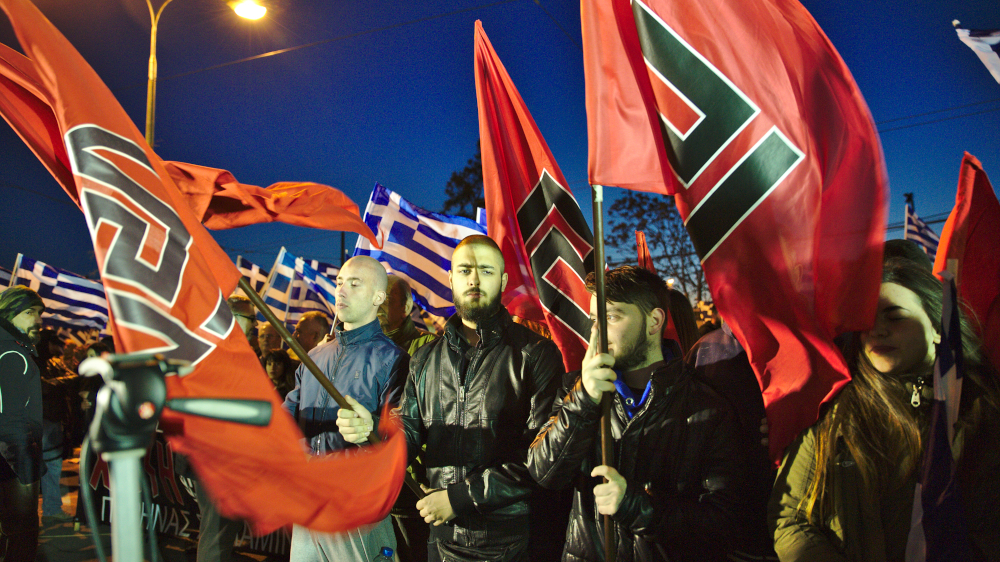 Golden Dawn members hold flags with the meander symbol at rally in Athens