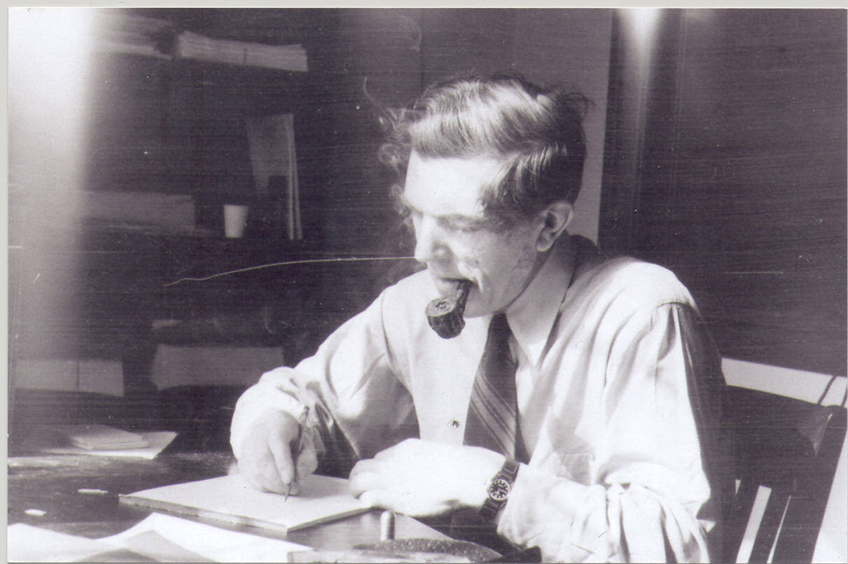 Black and white photo of a man writing on a notebook.