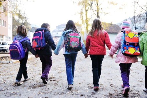children holding hands on their way to school
