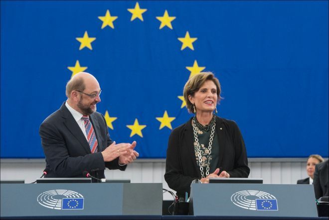 en kvinne og en mann i EU-parlamentet. Mannen klapper,