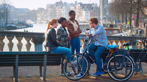 A small group of young people talking on a bridge.