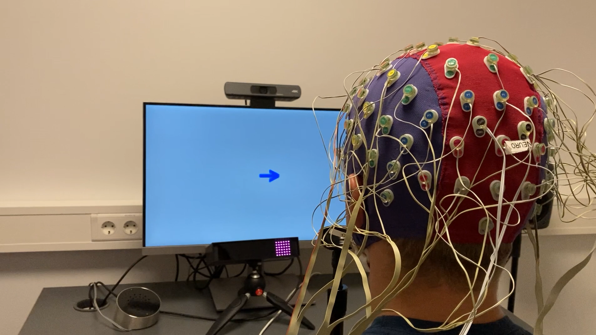 Man wearing an EEG cap while doing a task on a computer