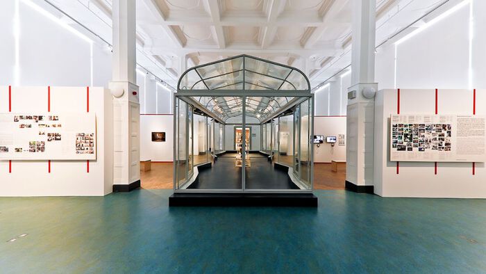 Museum exhibition, green floors, white celings, columns