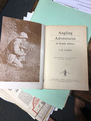 Picture of an old, black-and-white book named "Angling Adventures in South Africa", written by Yates. On the left page there is a picture of a man in a flyfishing costume. Photo: Knut Gunnar Nustad